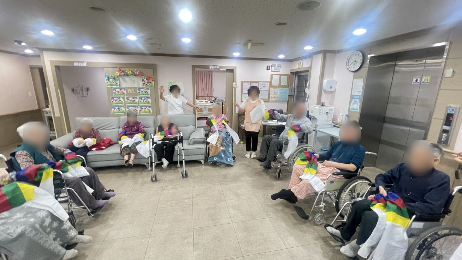 요양원 거실에서 한삼을 들고 함께 체조하는 어르신들